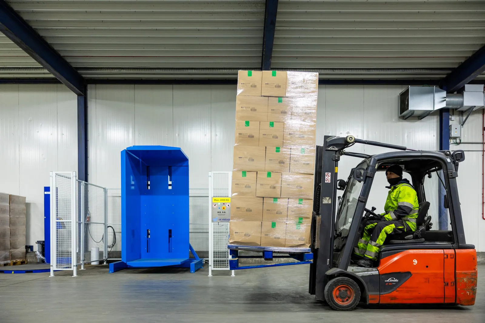 Heftruck rijdt een beladen pallet naar de palletkantelaar PalletRotator K11
