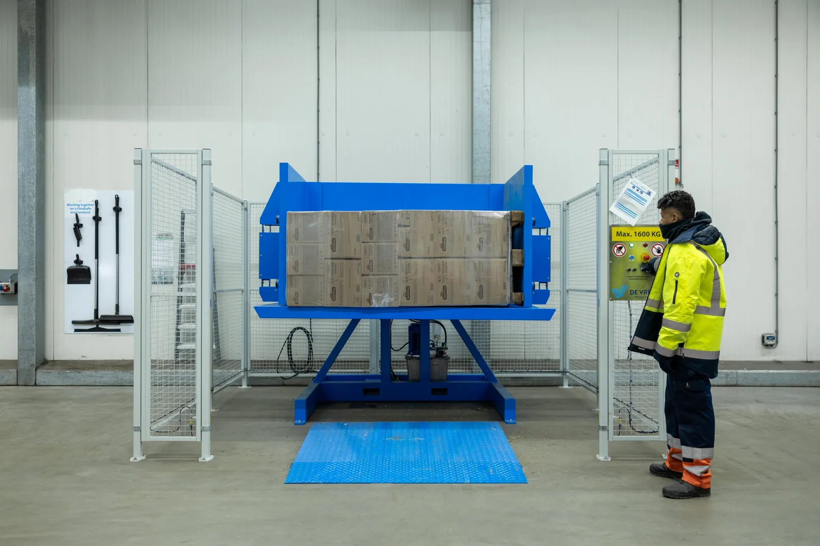 Palletkantelaar PalletRotator EPT met gekantelde pallet en operator bij het bedieningspaneel